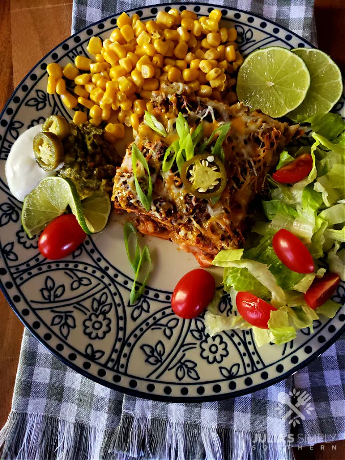 Dinner plate with Mexican casserole and sides with checked towel