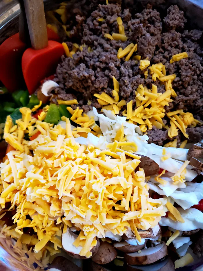 Combine cheesy ground beef and cabbage casserole ingredients in a mixing bowl with cream of mushroom soup