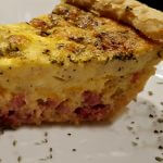 ham & cheese quiche slice on a white plate