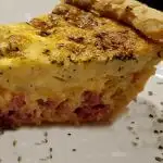 ham & cheese quiche slice on a white plate