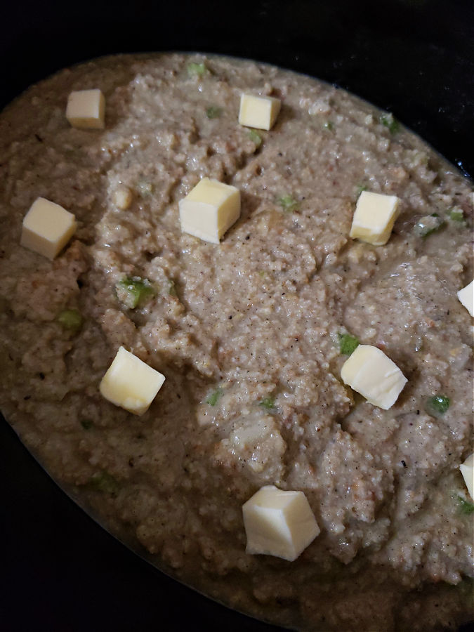 stuffing mixture in the slow cooker with small pieces of butter on top