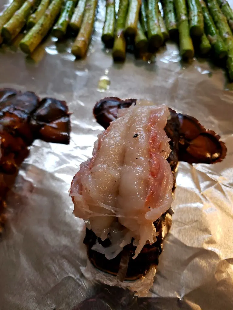 Preparing lobster by butterflying the tail and placing on a baking sheet