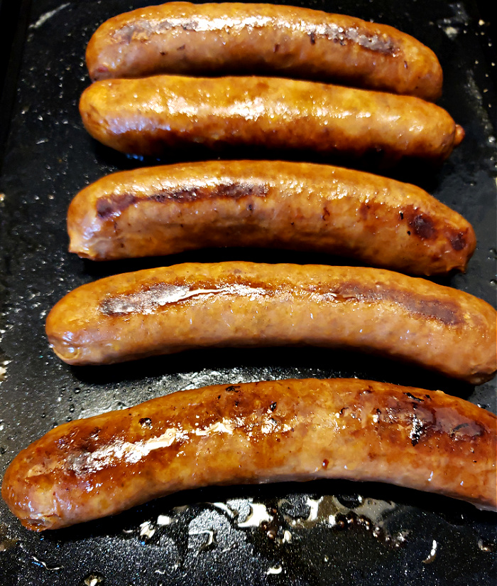 Italian Sausages cooking on a hot griddle