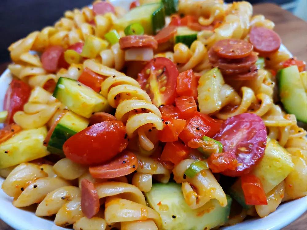 white bowl with marinated pasta salad