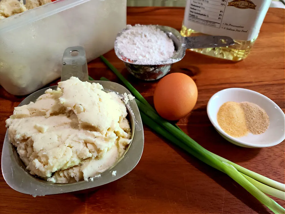 cutting board with ingredients laid out to prepare leftover mashed potato cakes