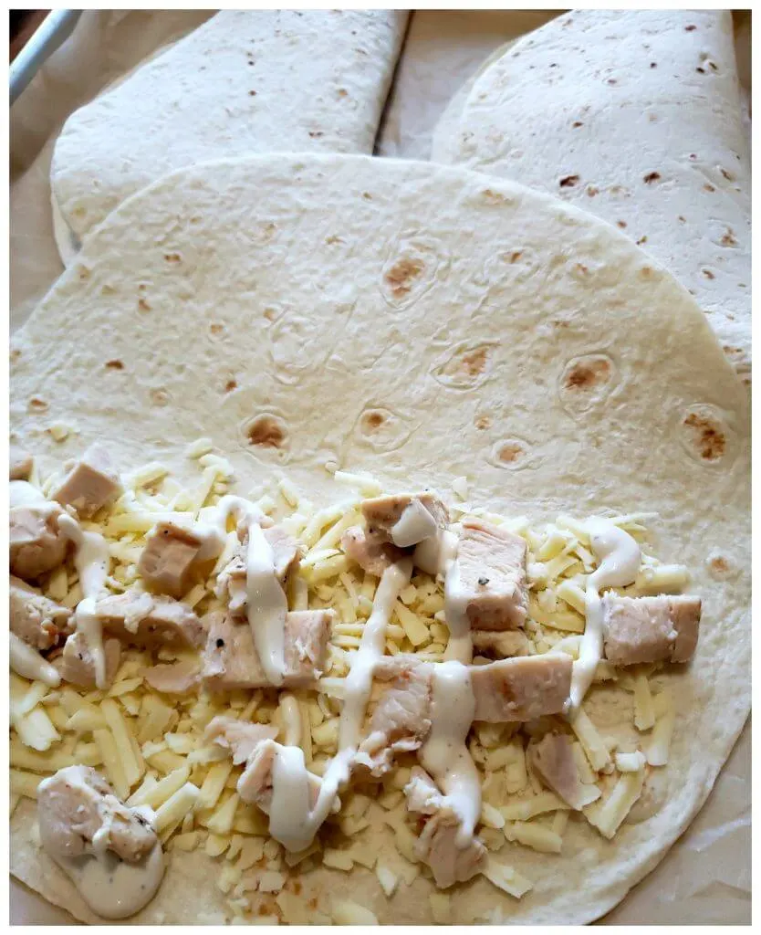 Layering ingredients inside a large flour tortilla before baking