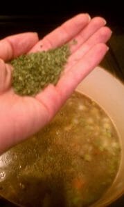 Adding fresh herbs to soup