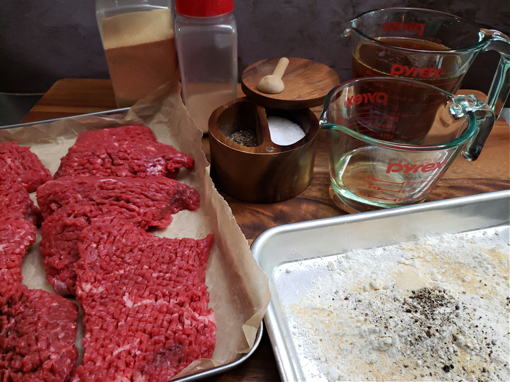 Ingredients for preparing cube steak in the slow cooker arranged on a cutting board