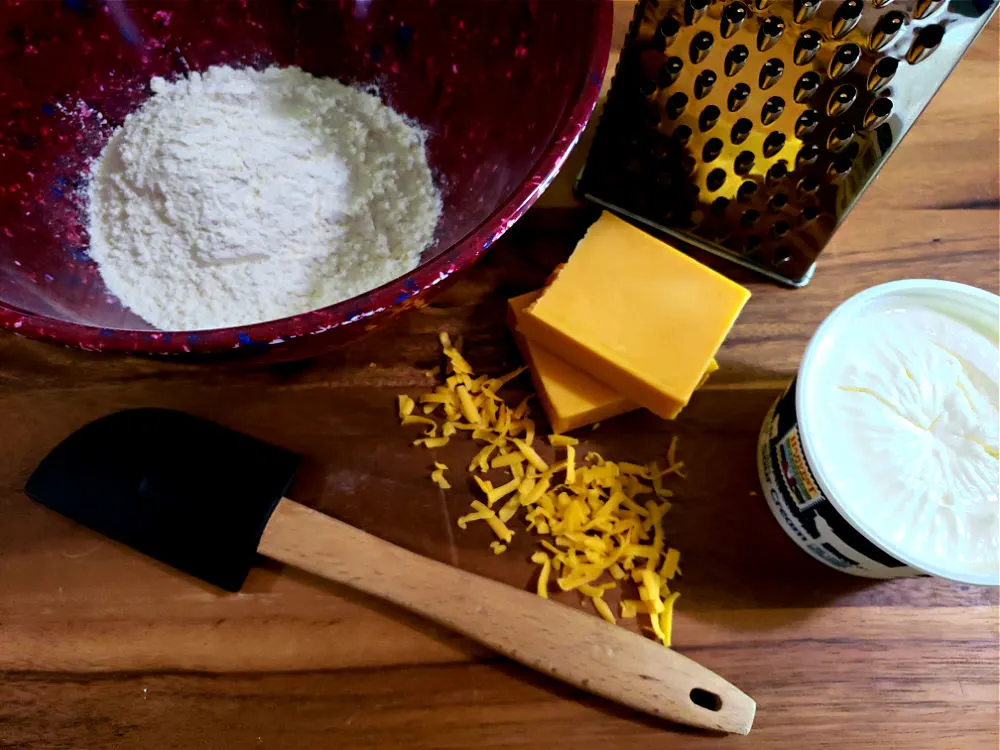 wooden board with ingredients to make sour cream cheese biscuits