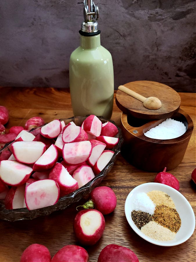 Ingredients for preparing roasted radishes in the oven arranged on a wooden cutting board