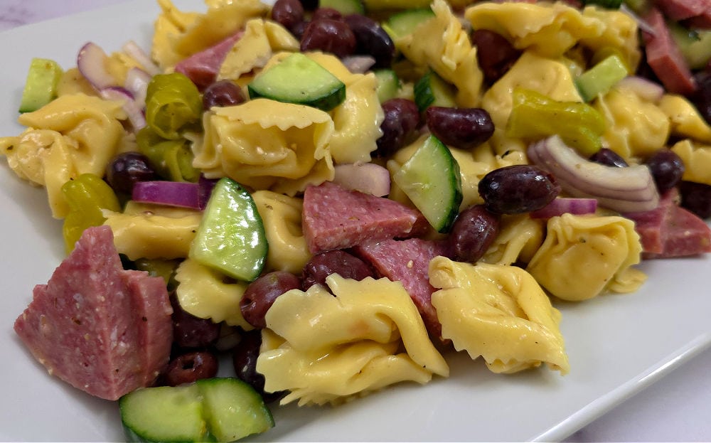 Tortellini pasta salad on a white serving plate