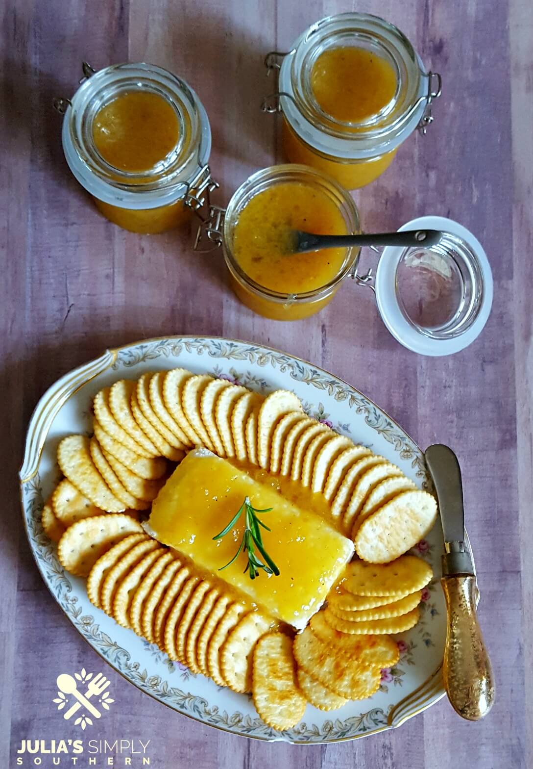 Holiday Appetizer made with cream cheese and Jezebel Sauce served with crackers on a vintage floral platter