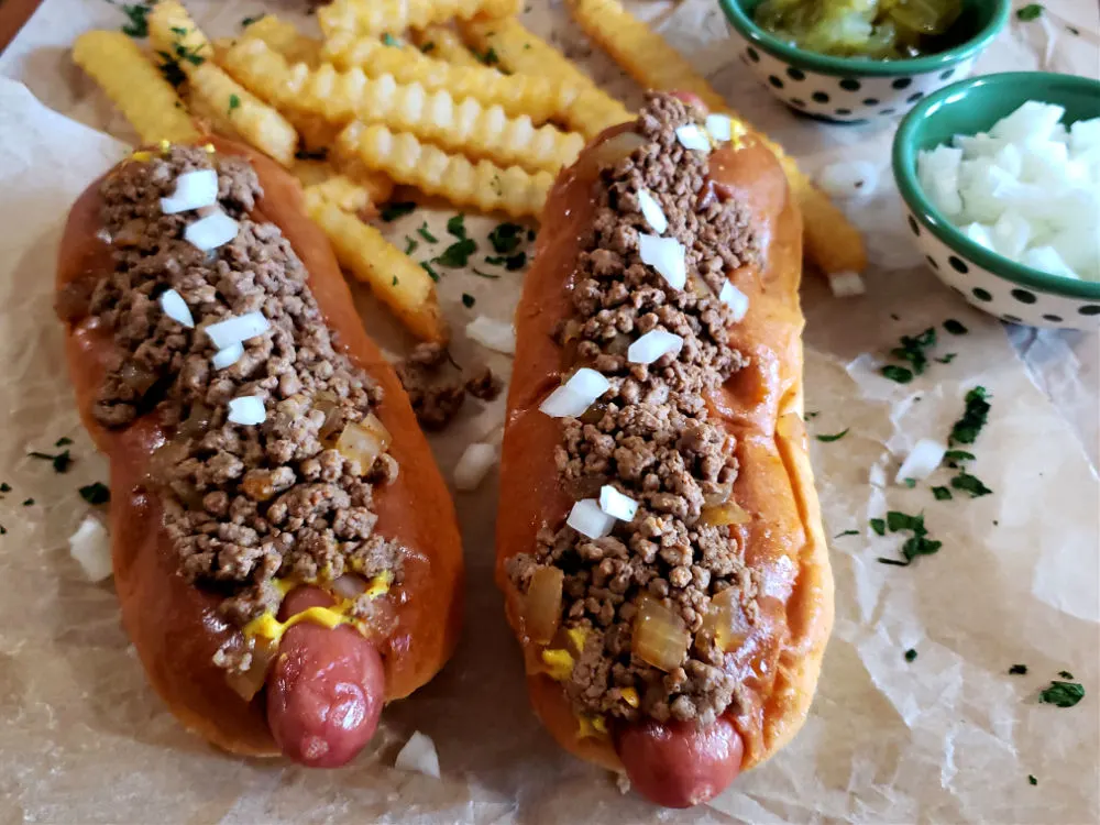 two chili dogs with fries topped with southern style hot dog chili and onions