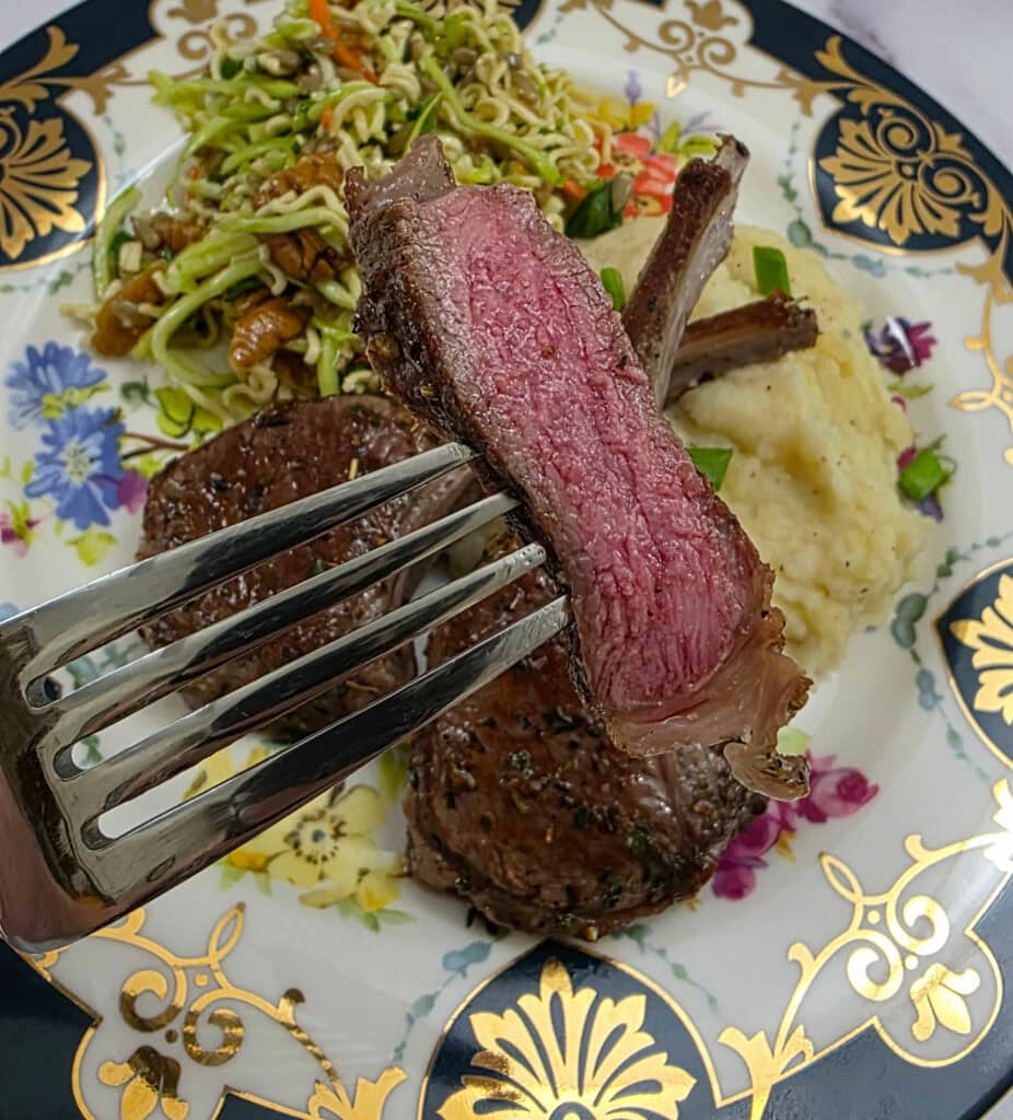 Slice of seared lamb chop on a fork