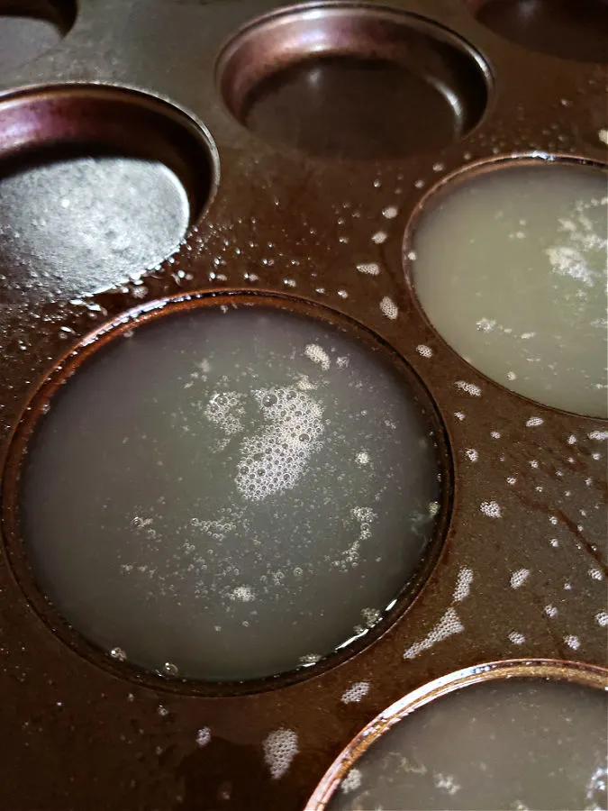 Liquid eggs in a muffin pan reading to go into the oven to bake