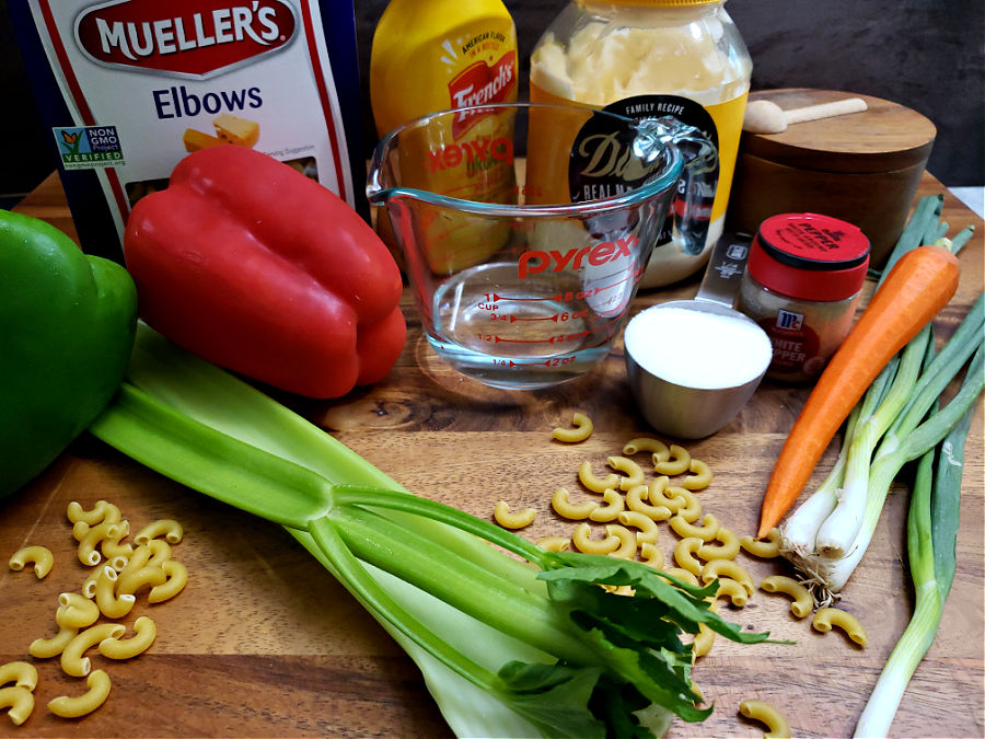 wooden cutting board with the ingredients for making old fashioned macaroni salad