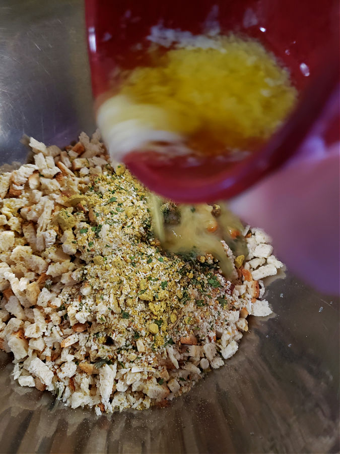 pouring melted butter to combine with stuffing mix