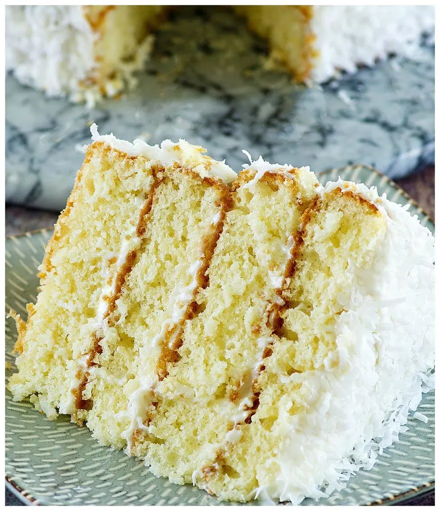 Delicious layered Southern coconut cake recipe with frosting topped with flaked coconut