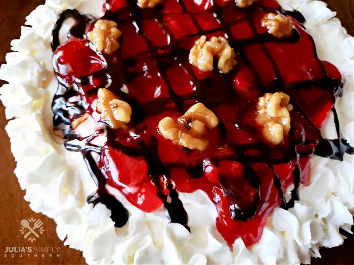 pie with whipped cream, strawberry, chocolate syrup and candied nuts