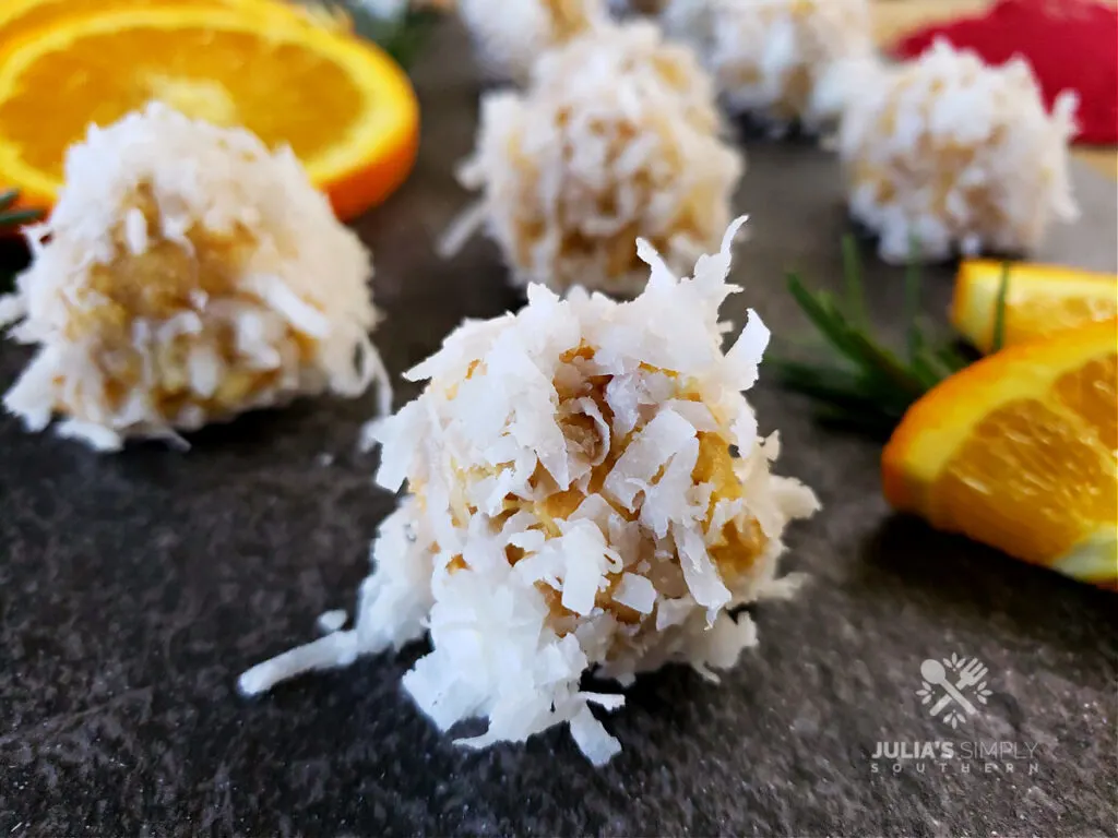 Orange Balls on a serving platter with fresh orange slice garnishes