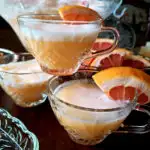 Sherbet Punch Recipe in a crystal punch bowl with punch glasses garnished with orange slices