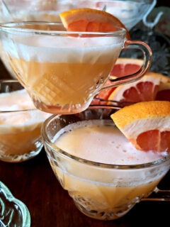 Sherbet Punch Recipe in a crystal punch bowl with punch glasses garnished with orange slices