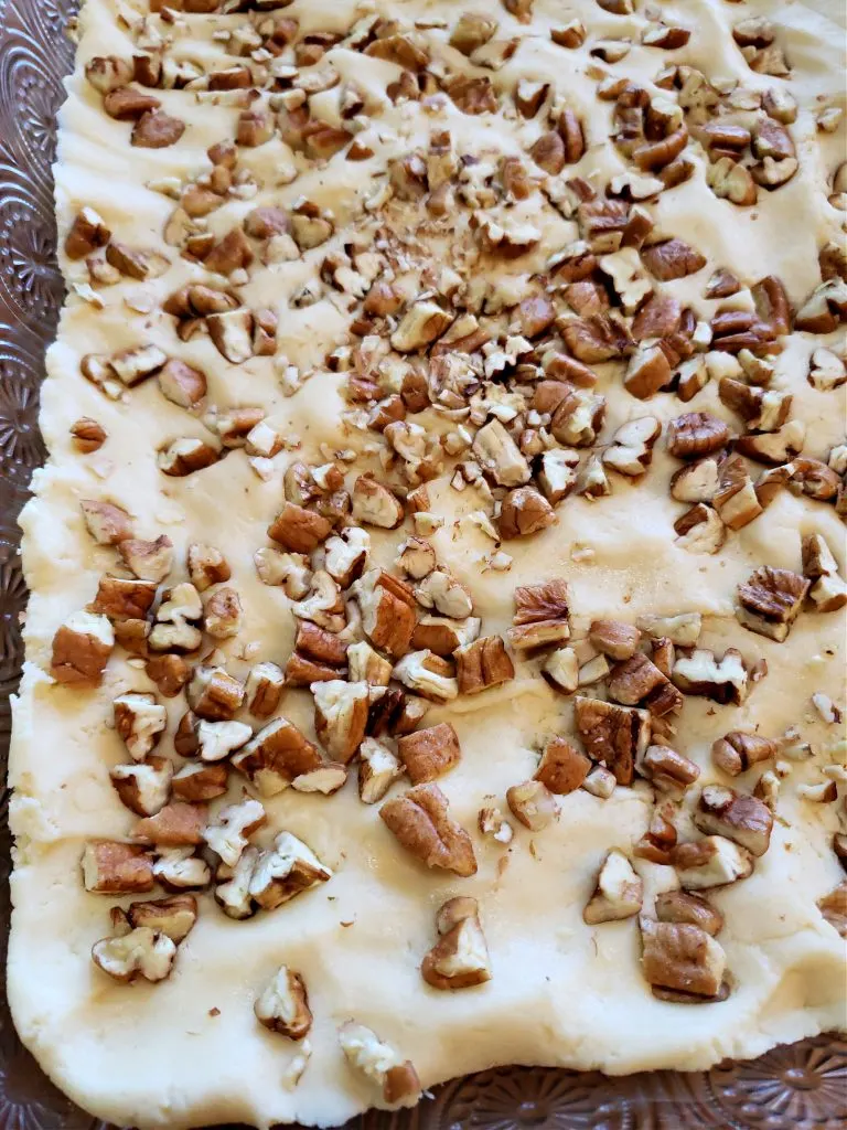 Pressing pecans into goody bar cake dough