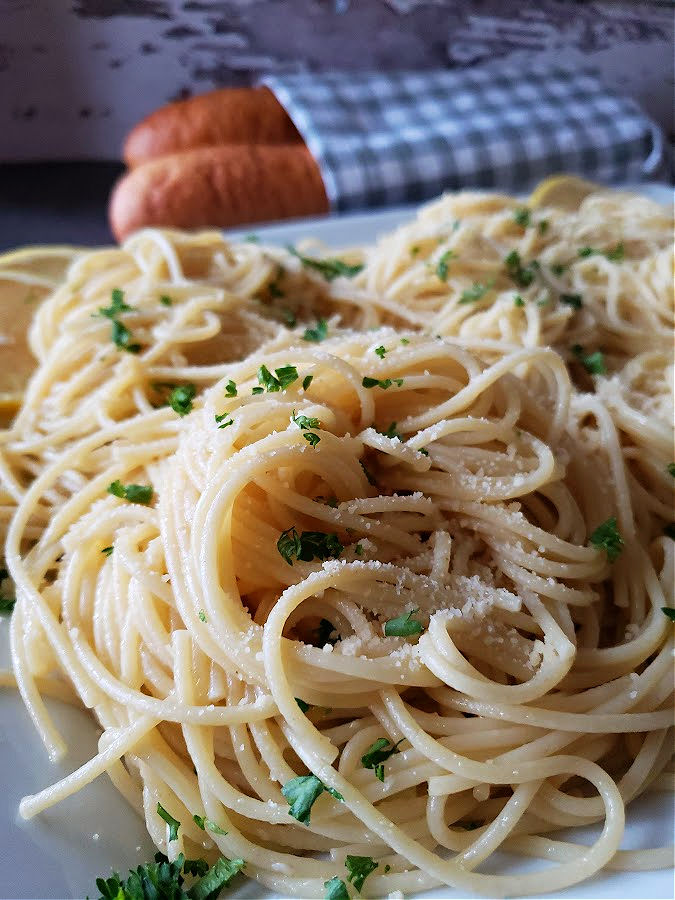 Pasta with Infused Olive Oil sauce and Parmesan Cheese garnished with fresh parsley served with Italian bread