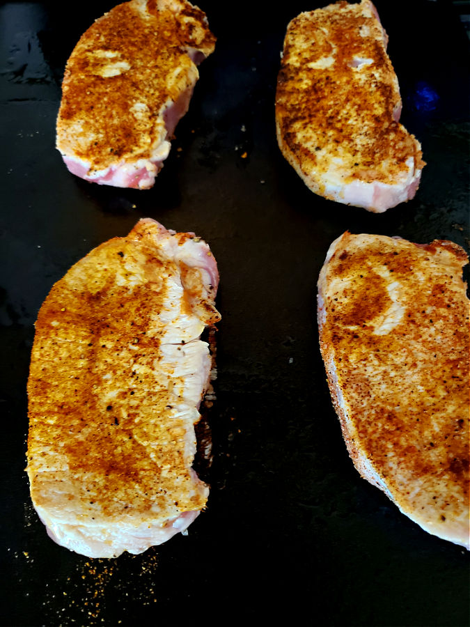 searing pork chops on a cast iron griddle 