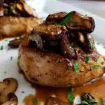 Pork Chops Recipe with Mushrooms on a serving platter garnished with parsley