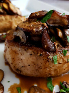 Pork Chops Recipe with Mushrooms on a serving platter garnished with parsley