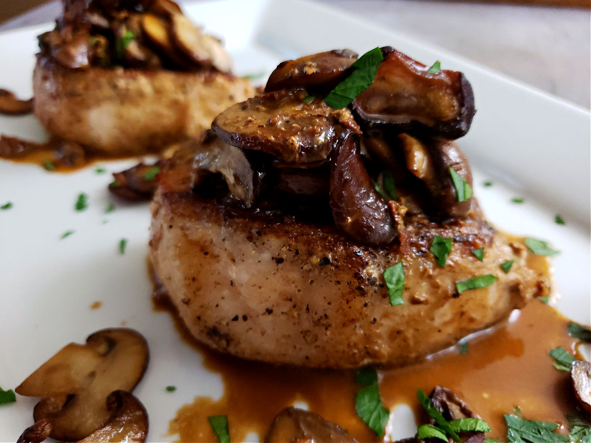 Pork Chops Recipe with Mushrooms on a serving platter garnished with parsley
