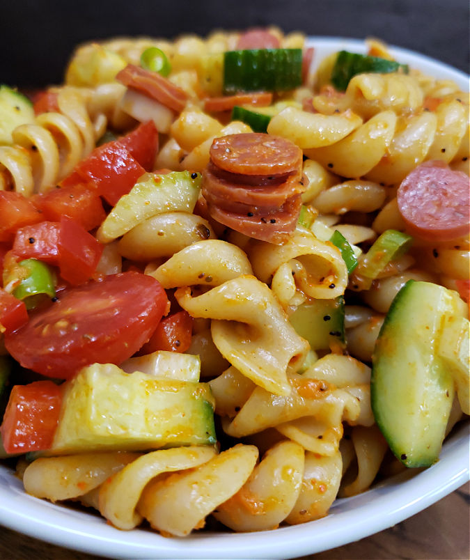 pasta salad supreme with Italian dressing, veggies, pepperoni, and Salad Supreme seasoning in a white serving bowl