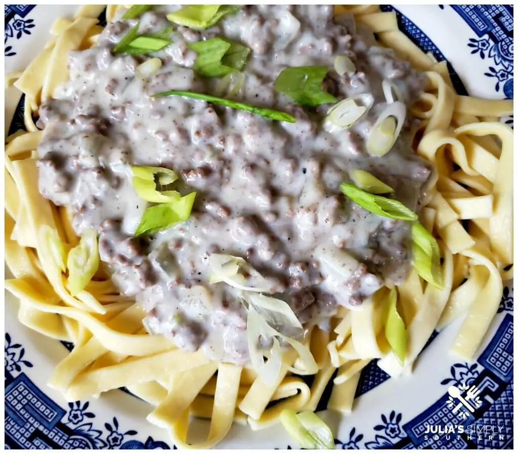 Blue and White china plate with a serving of noodles topped with hamburger gravy