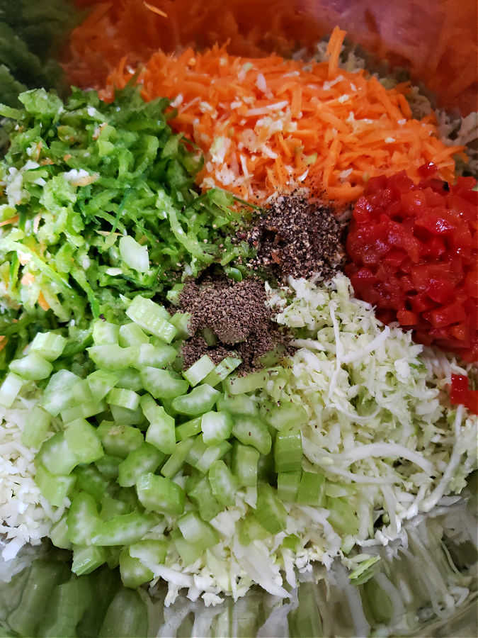 Cabbage, peppers, carrots and other ingredients in a mixing bowl for making Amish coleslaw