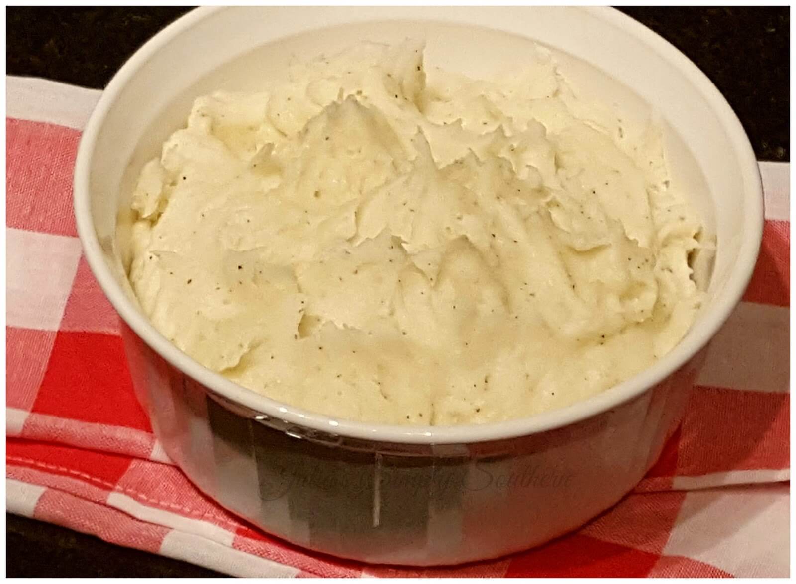 Best Southern Mashed Potatoes with Duke's Mayonnaise in a white bowl with gingham cloth