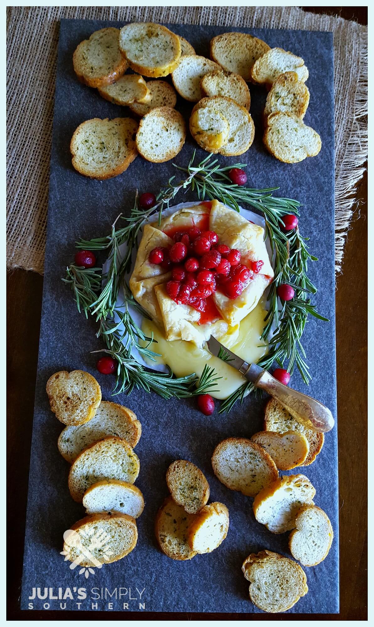 Baked brie in pie crust with fresh cranberry sauce for Christmas served with crostini bread - Holiday Brie en Croûte Recipe