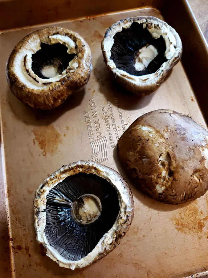 Portobello mushroom caps on a baking sheet