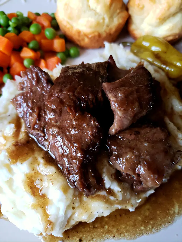 Mississippi Pot Roast with sides and gravy on a dinner plate