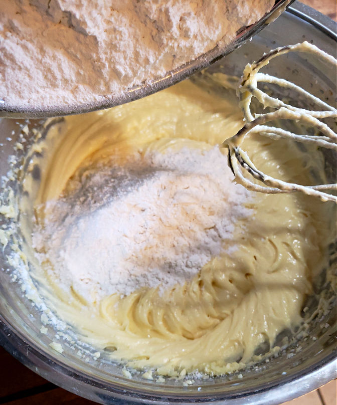 Adding ingredients to a mixing bowl for scratch made cake