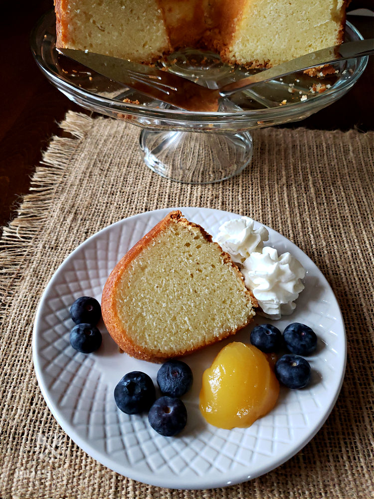 Best Pound Cake Recipe - served with lemon curd, blueberries and whipped cream on a white plate. Best Ever!