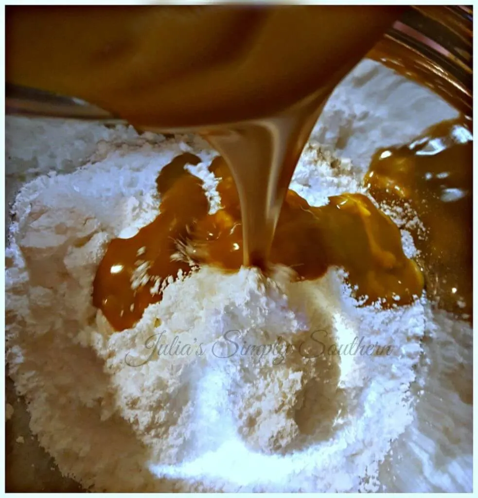 Pouring Peanut Butter mixture over powdered sugar