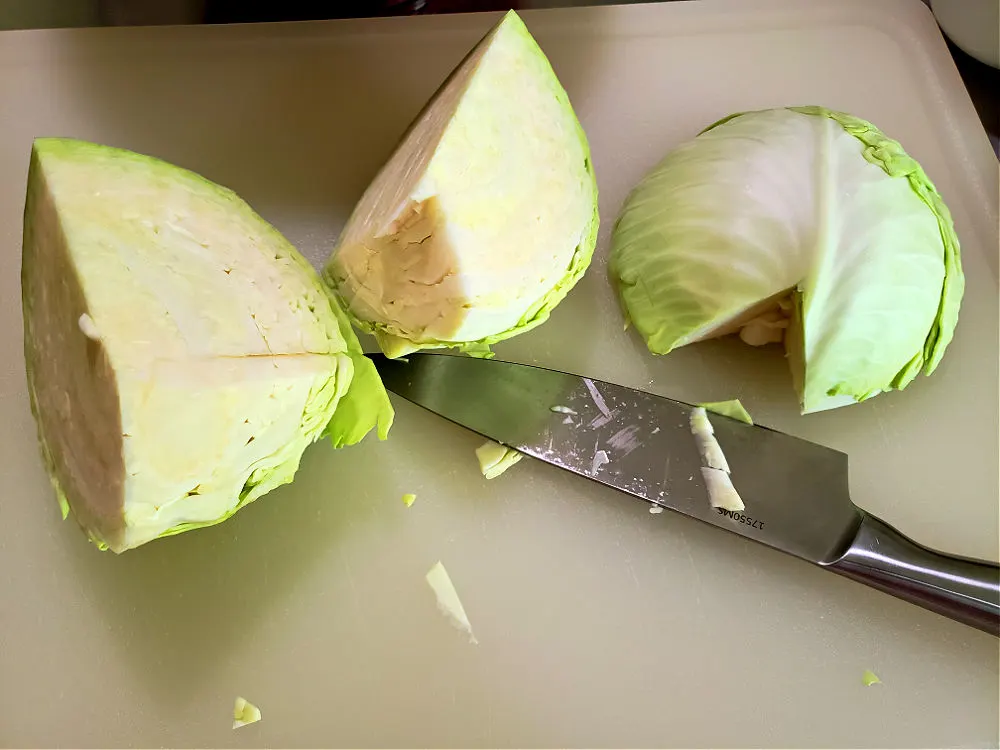 Prep cabbage by removing the core to make homemade coleslaw