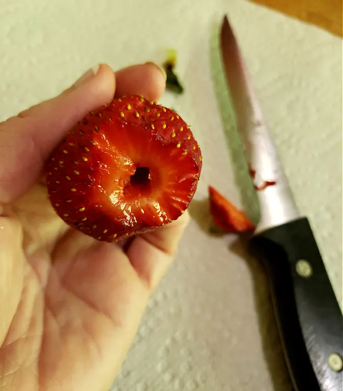 prepping berries by removing stems and hulls then washing to clean