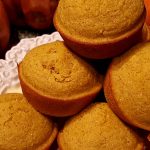 Pumpkin Cornbread Muffins on a serving tray next to decorative pumpkins