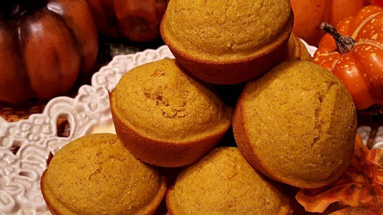 Pumpkin Cornbread Muffins on a serving tray next to decorative pumpkins