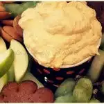 Pumpkin fluff dip on a platter with fruit and cookies