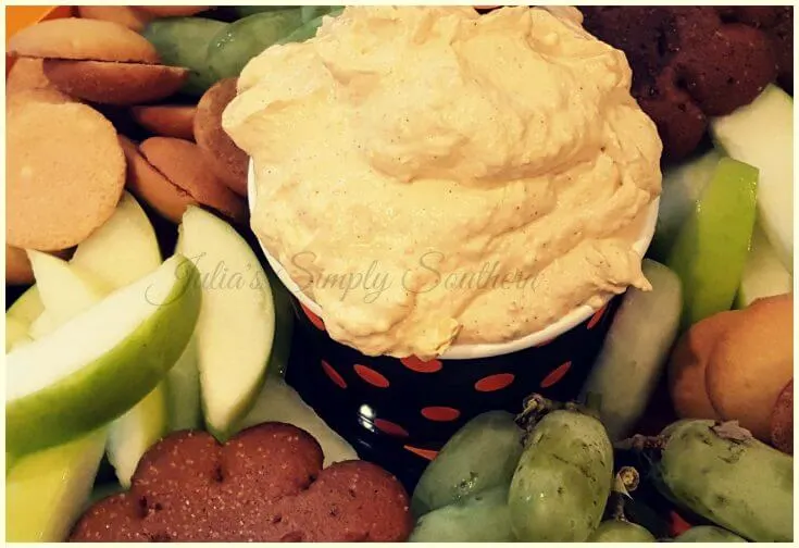 Pumpkin fluff dip on a platter with fruit and cookies