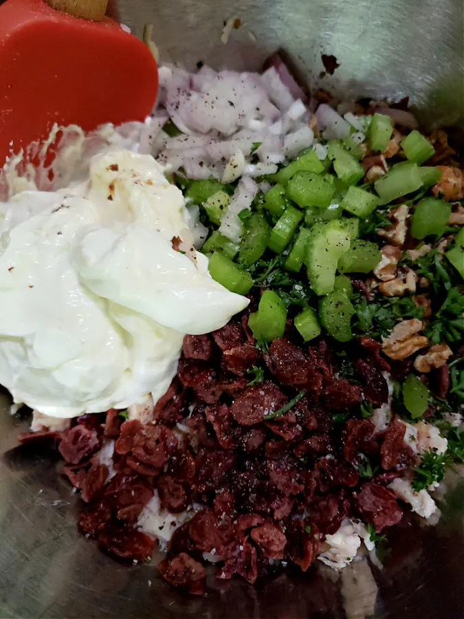 mixing up chicken salad in a mixing bowl