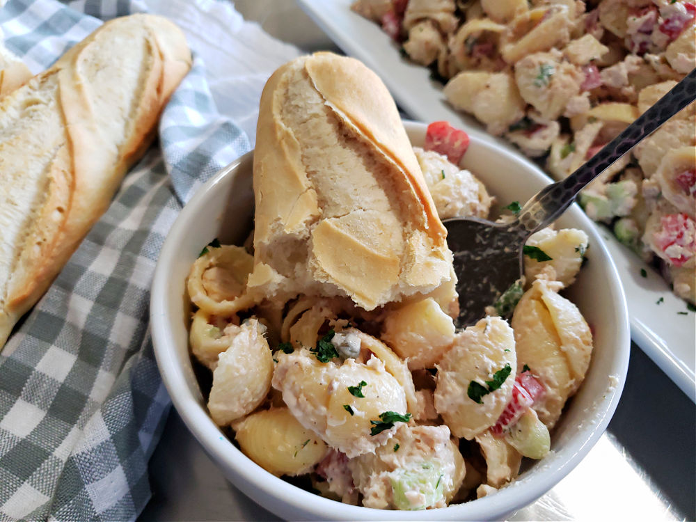 bowl of salmon pasta salad with a hunk of crusty bread